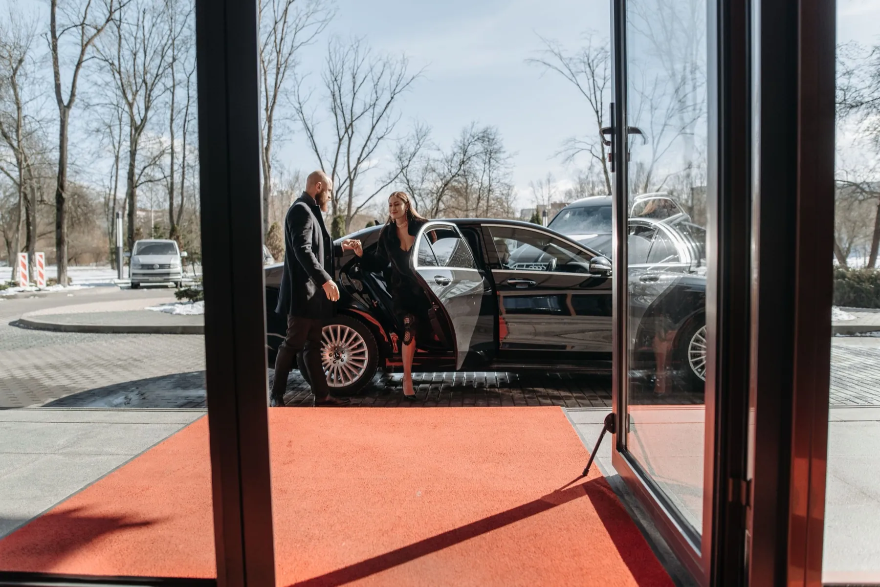 Guest stepping out of a car onto a red carpet